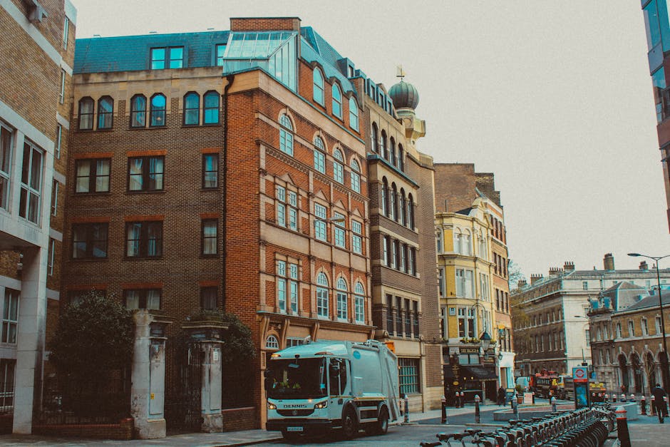 A street scene showing multi-storey residential buildings with distinct architectural styles, including brick facades and large windows, situated on Avenue Road near a residential estate. In the foreg